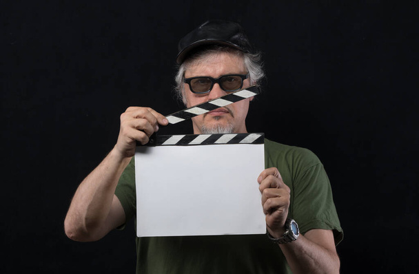 director de cine masculino con aplaudidor de película sobre fondo negro - Foto, Imagen
