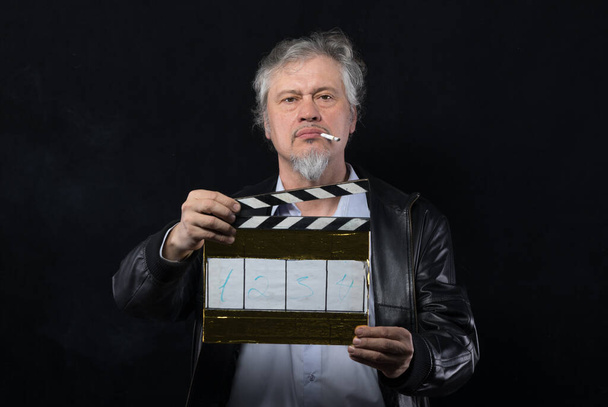 黒い背景に映画クラッパーが付いている男性の映画監督 - 写真・画像