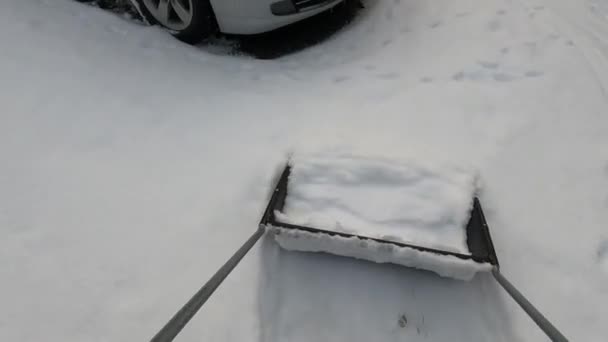 Σκούπισμα χιόνι από την αυλή με ένα φτυάρι χιονιού - Πλάνα, βίντεο