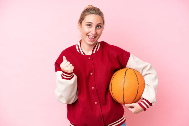 Pembe arka planda izole edilmiş genç basketbolcu kadın galibiyeti kutluyor. - Fotoğraf, Görsel