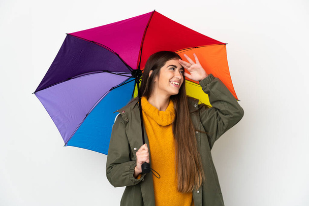 Mujer joven sosteniendo un paraguas aislado sobre fondo blanco sonriendo mucho - Foto, imagen