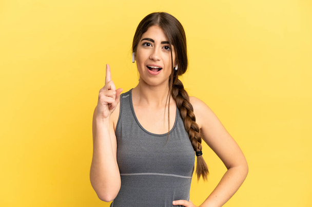 Sport kaukázusi nő elszigetelt sárga háttér gondolkodás ötlet rámutatva az ujját fel - Fotó, kép