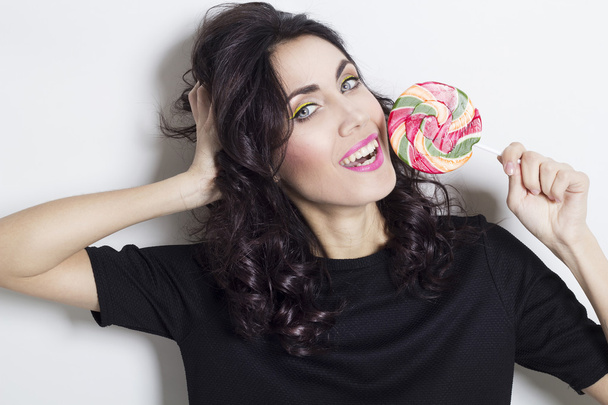 Portrait of beautiful young woman with lollipop - Foto, imagen