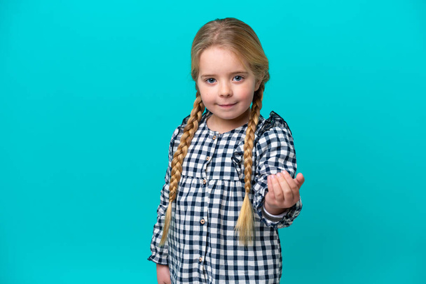 Little caucasian girl isolated on blue background inviting to come with hand. Happy that you came - Fotografie, Obrázek