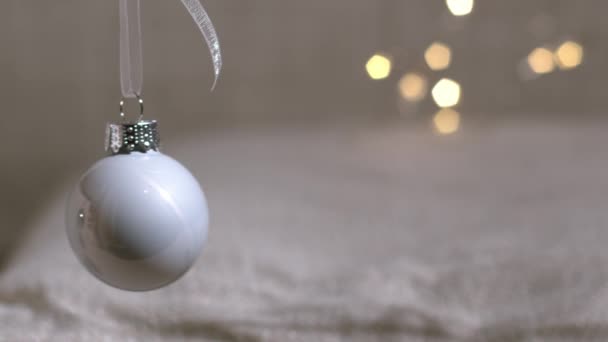 Белая рождественская безделушка с золотыми боке огни 4k замедленной съемки селективного фокуса  - Кадры, видео