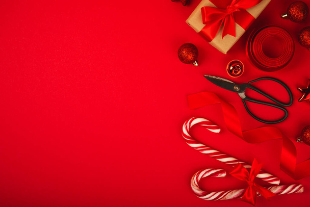 Рождественские конфетки на красном фоне. Поздравительная открытка. Концепция рождественских и новогодних праздников. Зима. Плоскость, вид сверху, копировальное пространство. - Фото, изображение