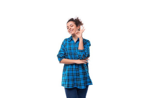 europejski przyjazny młoda dama z kręcone kucyk fryzura ubrana w niebieską koszulę z kratę wzór. - Zdjęcie, obraz