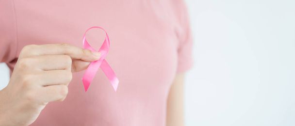 Woman hold pink ribbon breast cancer awareness. Female health check consciousness. international Women Day and World Cancer Day. sign cancer, Symbolic, health care, support patients, timely diagnosis - Foto, Imagen
