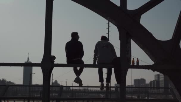 18. března2022. Mnichov, Německo Hackerbrucke. Lidé relaxovat sedí na mostě v blízkosti centrálního autobusového nádraží v München a vychutnat nápoje a slunečné počasí. Oblíbené místo setkání pro mladé lidi v Mnichově.  - Záběry, video