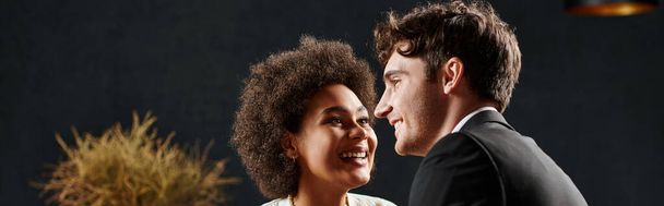 szczęśliwy Afryki amerykanka uśmiecha się i patrząc na mężczyznę podczas randki w Walentynki, sztandar - Zdjęcie, obraz