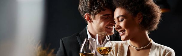 heureux couple interracial cliquetis verres de vin blanc pendant la date de la Saint-Valentin, bannière - Photo, image