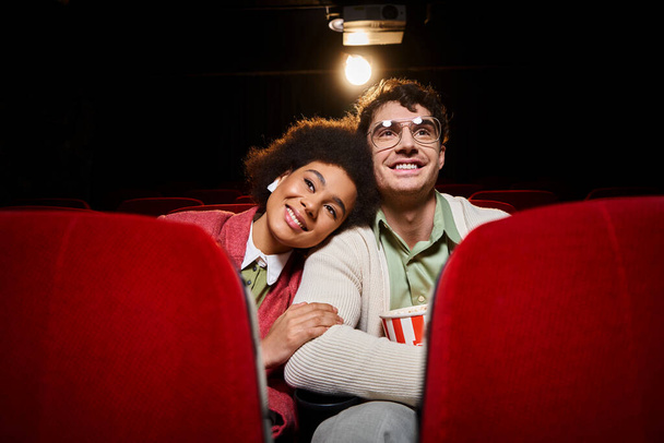 cheerful african american woman with her head on shoulder of her handsome boyfriend at cinema - Photo, Image