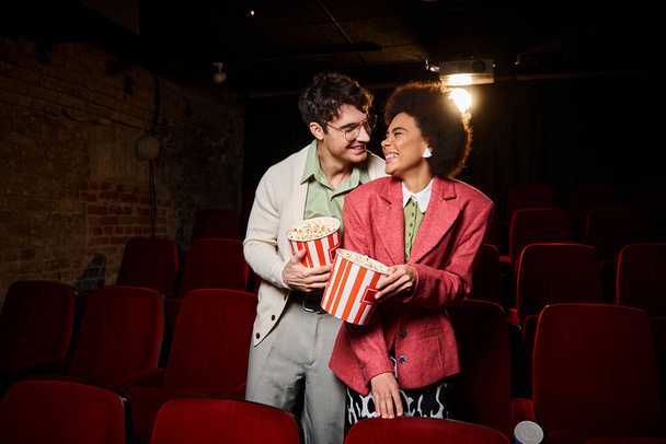 attraktive fröhliche vielfältige Paar lächelt einander liebevoll auf Datum im Kino, Valentinstag - Foto, Bild