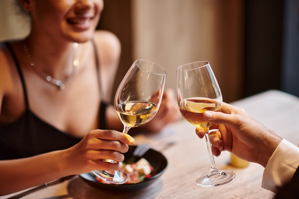 szczęśliwa para brzęczące kieliszki białego wina podczas randki w Walentynki, romantyczna kolacja - Zdjęcie, obraz