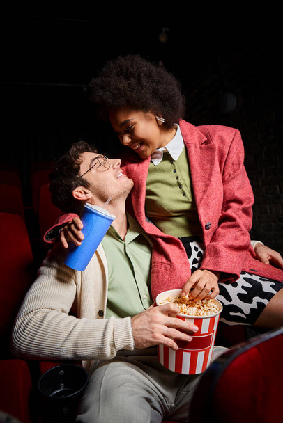 loving diverse couple in retro attire smiling at each other while on date at cinema, Valentines day - Photo, Image