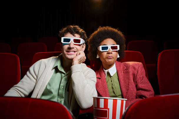 весела мультикультурна молода пара в ретро 3d окулярах чудово проводить час в кіно на їх побаченні - Фото, зображення