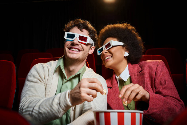 freudiges exotisches Paar mit Retro-3D-Brille, das am Valentinstag im Kino viel Spaß hat - Foto, Bild