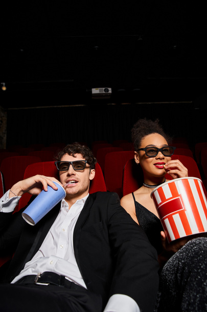 веселая привлекательная мультикультурная пара с трехмерными очками наслаждаясь кино во время свидания, День Святого Валентина - Фото, изображение