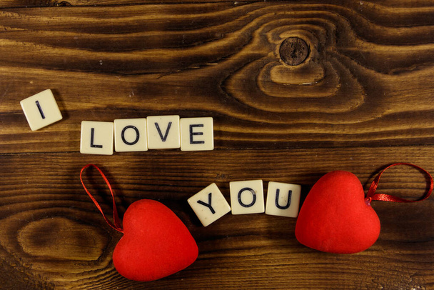 Corazones rojos y texto "Te amo" sobre fondo de madera. Vista superior
 - Foto, Imagen