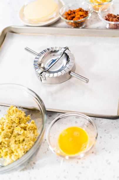 エンパナーダ生地を卵で満たし、朝食エンパナーダを卵とサツマイモで作る. - 写真・画像