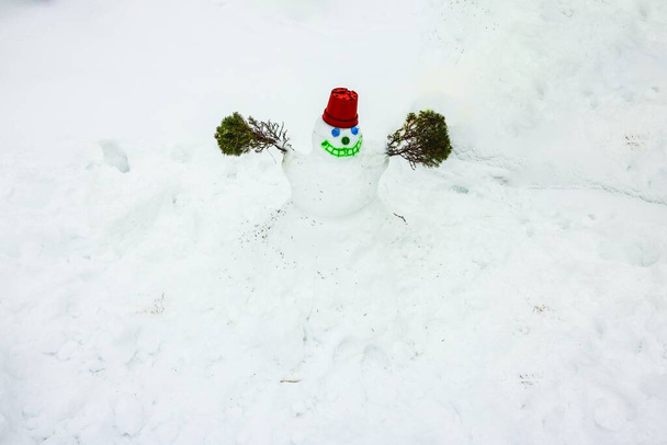 Widok z bliska na zabawnego bałwana, wykonany przez dziecko w zaśnieżonym ogrodzie. Szwecja. - Zdjęcie, obraz