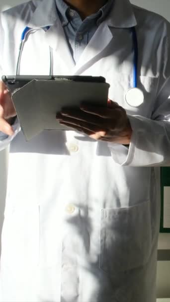 Klinikte elinde tablet bilgisayar tutan bir doktor. - Video, Çekim