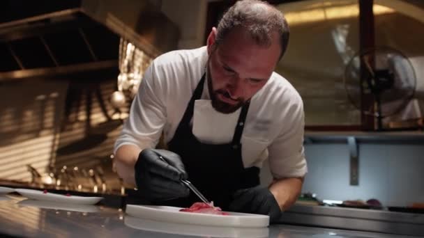 Séf elkészített friss tonhal carpaccio ehető virágokkal - Felvétel, videó
