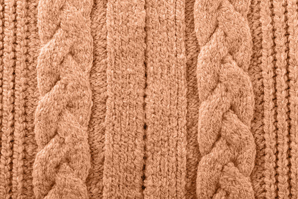 Gebreide textuur getint met kleur van het jaar 2024 perzik fuzz, wollen garen, gezellige winter herfst handgemaakte trui - Foto, afbeelding