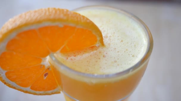 Стакан апельсинового сока на столе
 . - Кадры, видео
