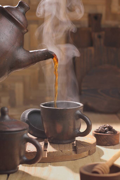 taza de té y tetera en la mesa de madera - Foto, Imagen
