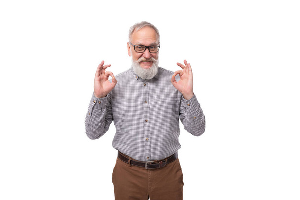 hombre de oficina maduro de pelo gris elegante con un bigote y barba vestido con pantalones y una camisa sobre un fondo blanco. - Foto, Imagen