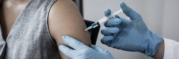 Εμβολιασμός των ασθενών, Ο γιατρός παρείχε ένα εμβόλιο με μια σύριγγα κατά ενός νέου στελέχους του ιού ή της γρίπης σε ένα σύγχρονο νοσοκομείο, Πρόληψη και υγεία έννοια. - Φωτογραφία, εικόνα