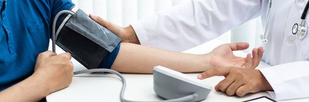 Ärztinnen verwenden Blutdruckmessgeräte und Stethoskop, um den Puls zu messen. Diagnose der Erkrankung der Patientin in einem modernen medizinischen Labor im Krankenhaus, medizinische Behandlung und Gesundheitskonzept. - Foto, Bild