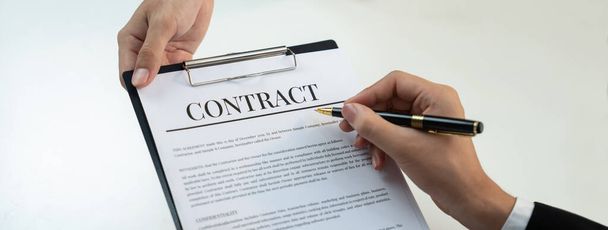 Business executive signing contract agreement document on the bale with the help from company attorney or lawyer service in law firm office. Business investing and finalizing legal processing. Shrewd - Photo, Image