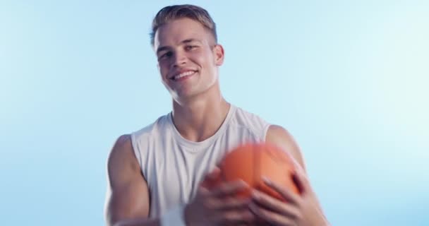 Sport, mosoly és kosárlabda férfi arccal a stúdióban a képzés, a kihívás és a verseny. Fitness, egészség és játékok portré személy kék háttér edzés és wellness. - Felvétel, videó