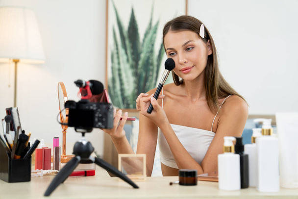 Young woman making beauty and cosmetic tutorial video content for social media. Beauty blogger smiles to camera while showing how to beauty care to audience or followers. Unveiling - Photo, Image
