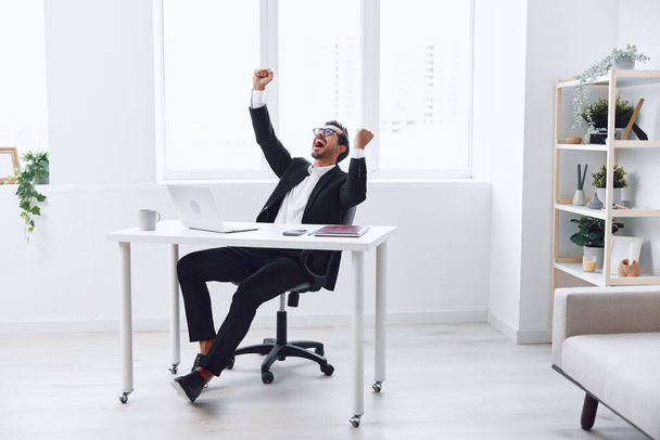 Успіх людини настільний офіс один працівник сучасний професійний перерва на роботі бізнес красива людина дивиться білий робочий ноутбук позитивність випадковий позаду дорослий відпочинок мрії - Фото, зображення