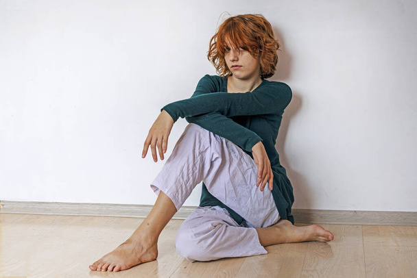 stijlvol tiener meisje zitten op de parketvloer in een yoga pose. - Foto, afbeelding