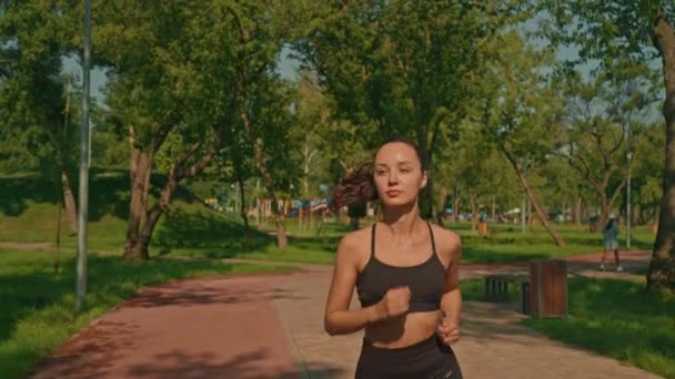 mujer corriendo en el parque de verano ejercicio cardiovascular fitness en la cámara lenta de la mañana - Imágenes, Vídeo