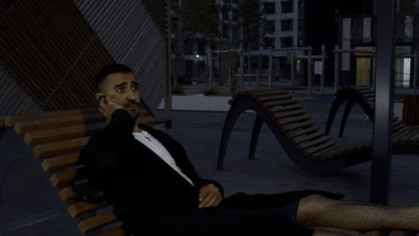 Mężczyzna rozmawiający przez telefon. Media. Wczesnym wieczorem, mężczyzna siedzący na ławce rozmawiający o sprawach zawodowych. Wysokiej jakości materiał 4k - Zdjęcie, obraz