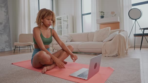 donna magra meditando seduta a gambe incrociate lezione di yoga online a casa - Filmati, video
