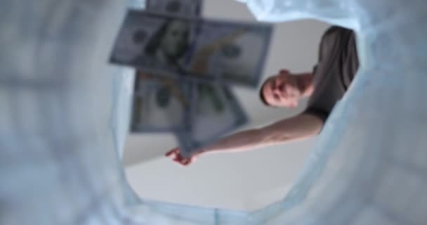 The person threw dollars into a trash bag, close-up. Unexpected expenses, concept slowmotion - Footage, Video