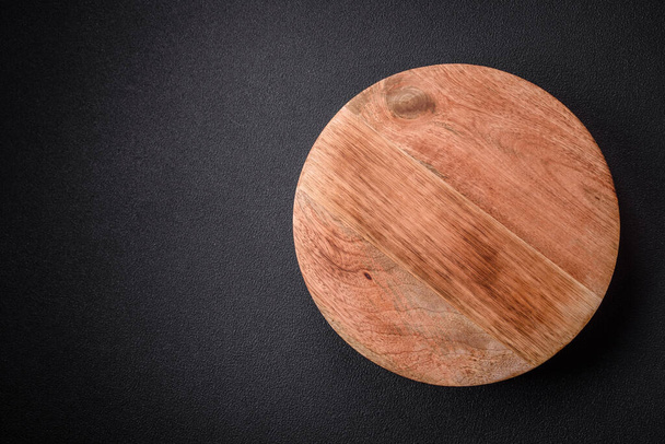 Beautiful round wooden cake stand on a textured concrete background. Kitchen utensil item - Photo, Image