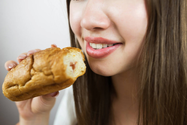 クロワッサンを食べている女性のクローズアップ写真,クロップ写真. - 写真・画像