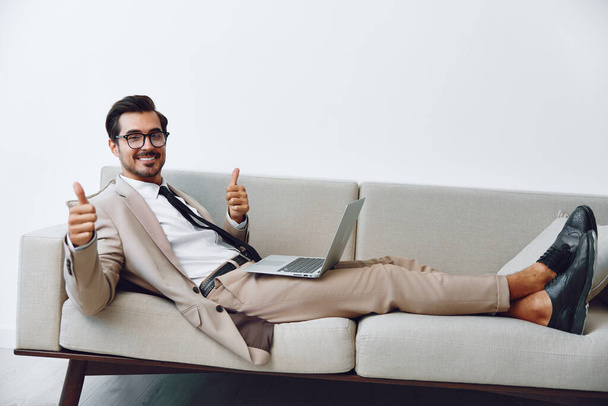 Сетевой человек диван выглядит стиль жизни деловые звонки рабочий ноутбук связи красивый успех смотреть уютный дом онлайн-компьютер с помощью случайных улыбающийся портрет парень диван видео расслабленной - Фото, изображение