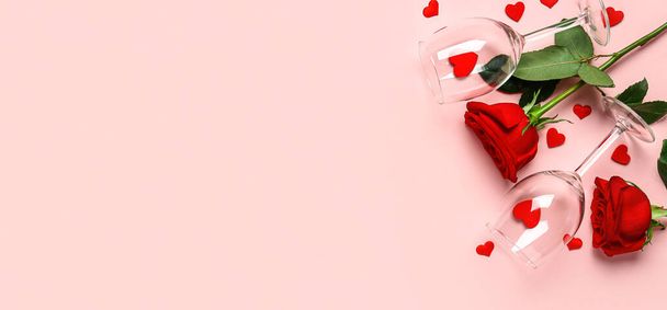 Γυαλιά κρασιού, τριαντάφυλλα και καρδιές σε ροζ φόντο με χώρο για κείμενο. Γιορτή του Αγίου Βαλεντίνου - Φωτογραφία, εικόνα