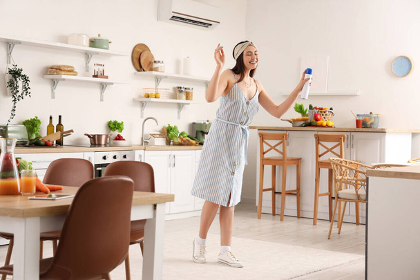 Jovem com ambientador de ar na cozinha - Foto, Imagem