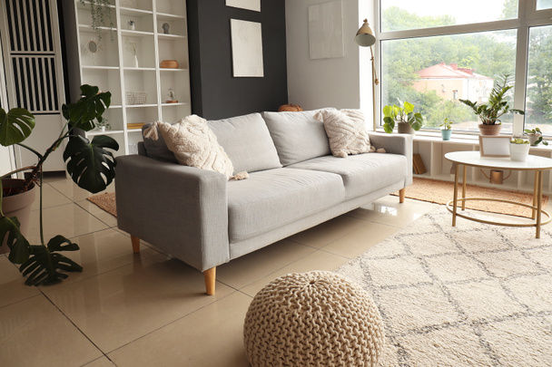 Интерьер современной гостиной с серым диваном и журнальным столиком - Фото, изображение