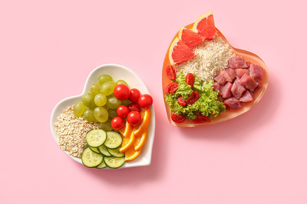 Placas con productos frescos y saludables sobre fondo rosa. Concepto de dieta - Foto, Imagen