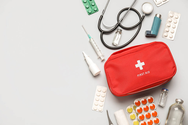 Kit di pronto soccorso e pillole su sfondo grigio - Foto, immagini